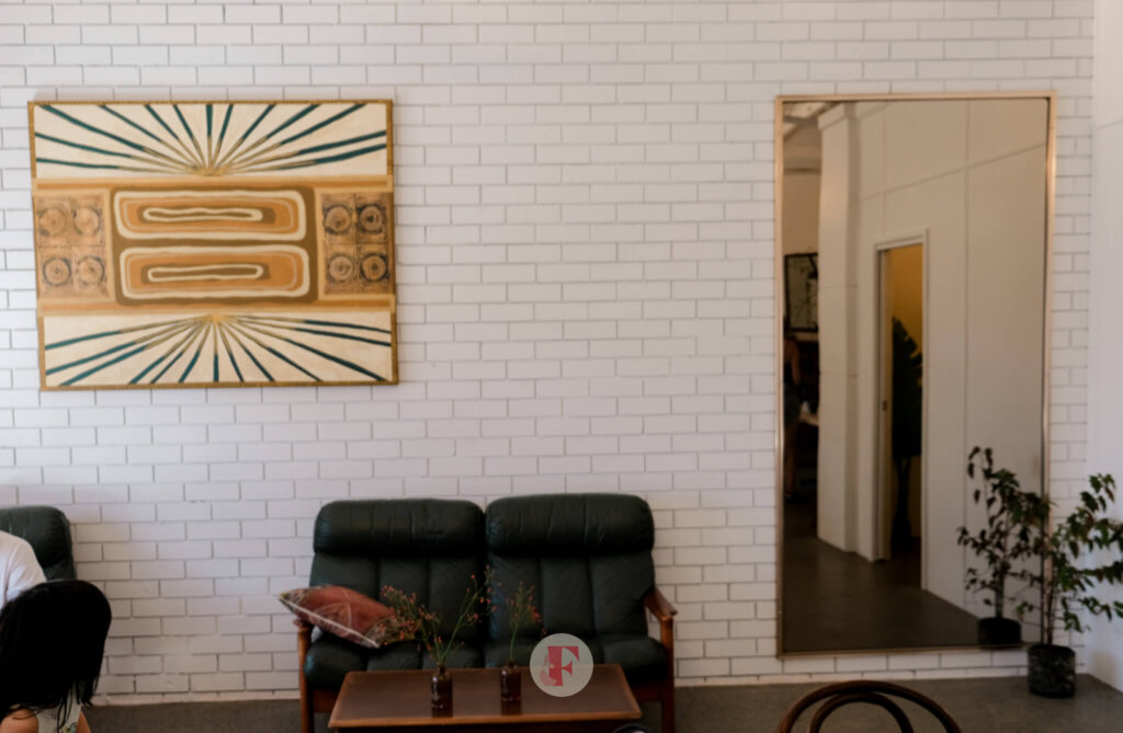 Mid century couch and a huge mirror and vintage painting on the wall