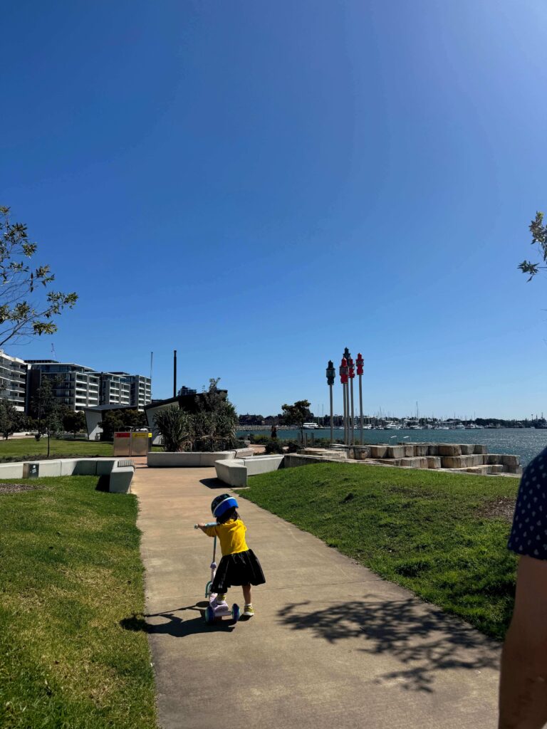 Toddler riding a scooter along the Honeysuckle foreshore