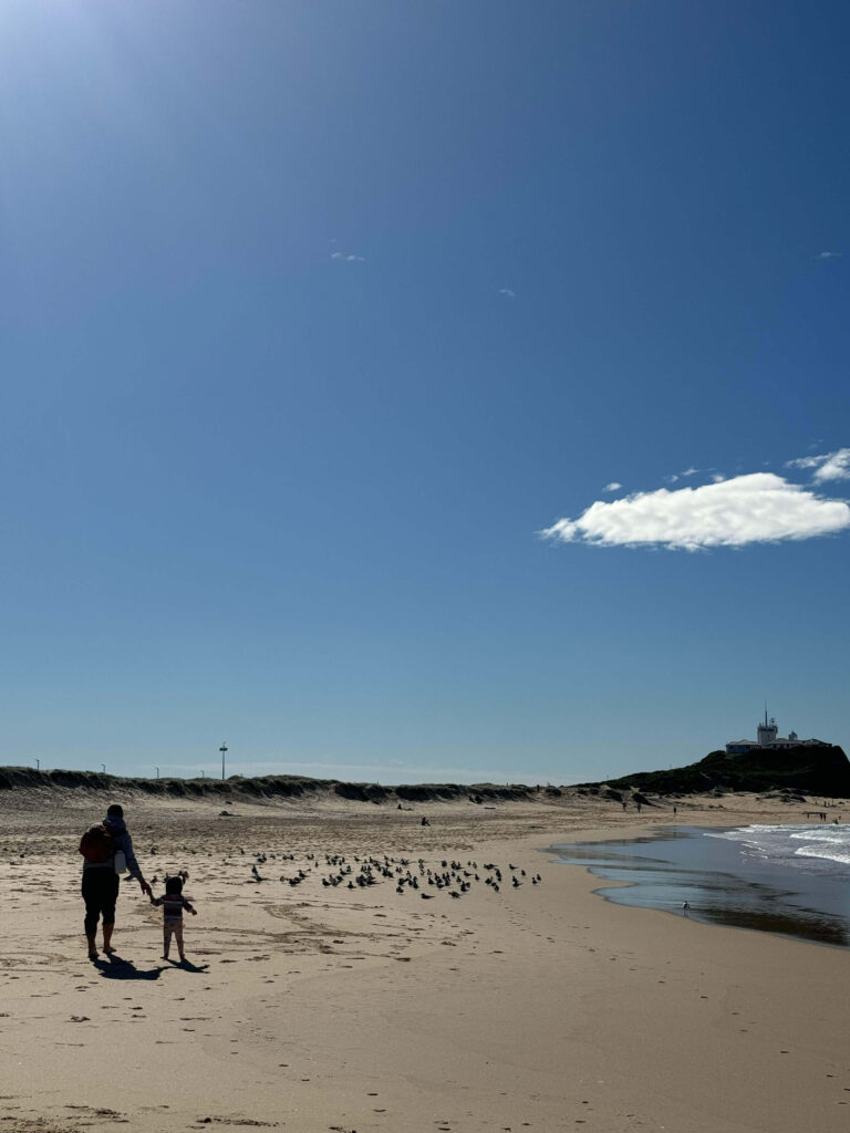 Father and child walking along Nobby's beach