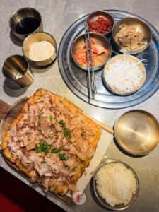 overlay shot of seafood pancake, banchans, and rice