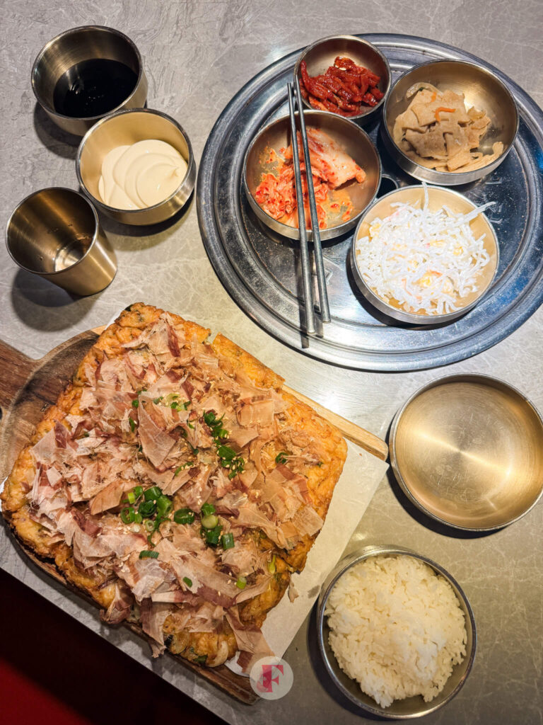 overlay shot of seafood pancake, banchans, and rice