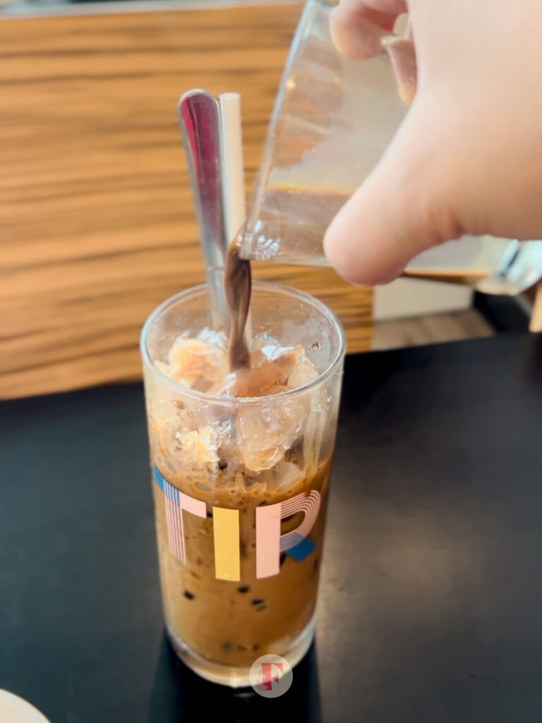 Pouring the coffee into a glass cup full of ice
